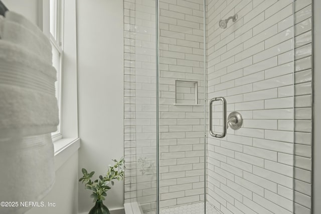 bathroom featuring a shower with shower door