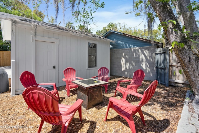 view of patio / terrace featuring an outdoor fire pit and a shed