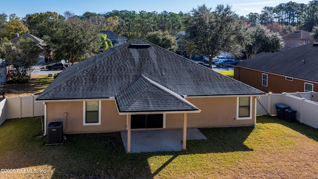 back of house featuring cooling unit, a lawn, and a patio area