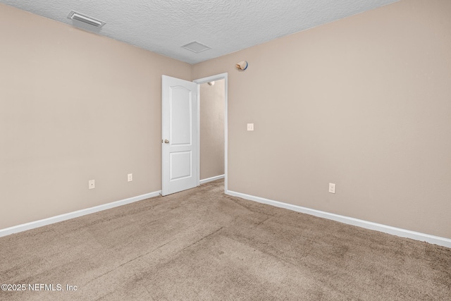 empty room with carpet flooring and a textured ceiling