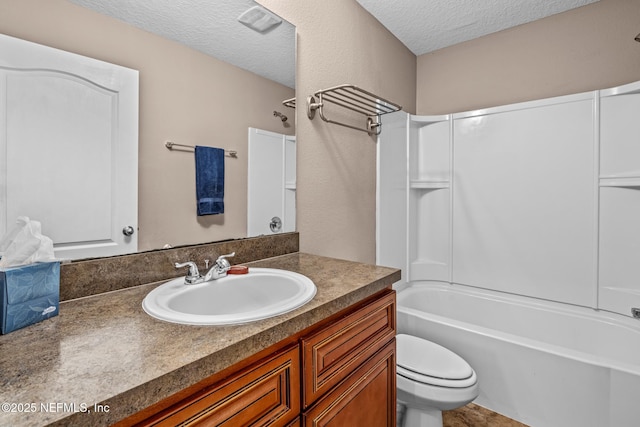 full bathroom with vanity, bathing tub / shower combination, a textured ceiling, and toilet