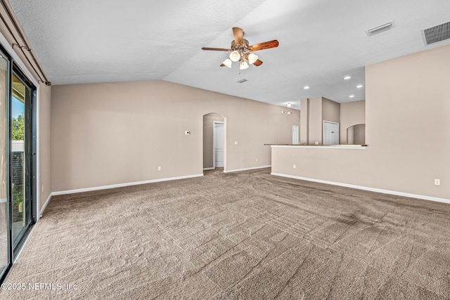 unfurnished living room featuring carpet floors, a textured ceiling, vaulted ceiling, and ceiling fan