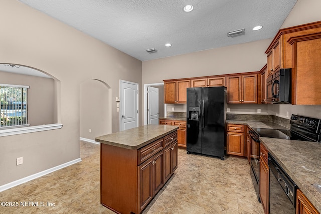 kitchen with black appliances, a center island, and a textured ceiling