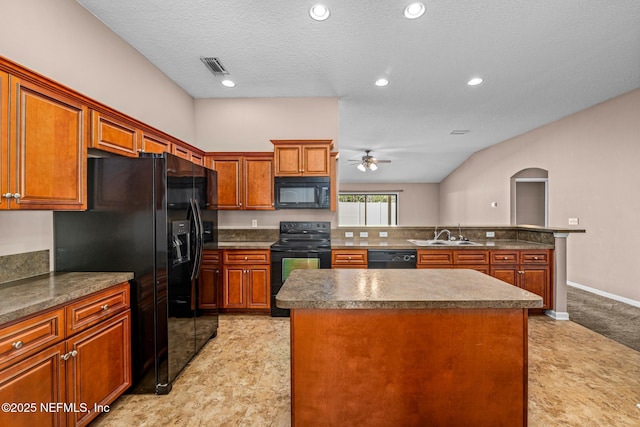 kitchen featuring sink, ceiling fan, a center island, black appliances, and a textured ceiling