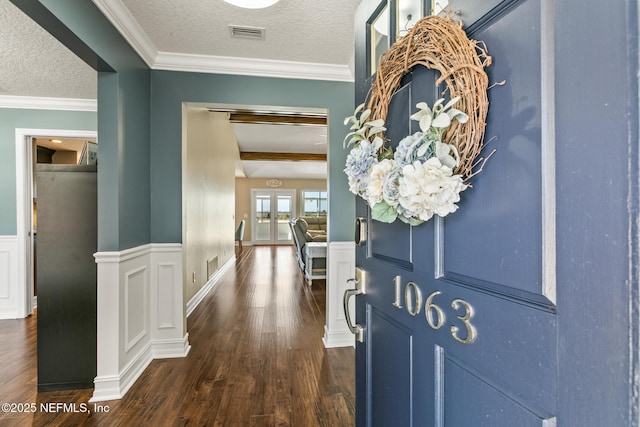 foyer with crown molding, dark hardwood / wood-style floors, and a textured ceiling