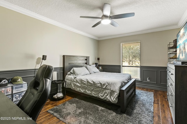 bedroom with dark hardwood / wood-style flooring, ceiling fan, ornamental molding, and a textured ceiling