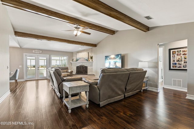 living room with a large fireplace, vaulted ceiling with beams, ceiling fan, dark wood-type flooring, and french doors