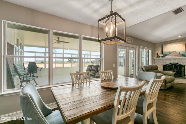 dining space with lofted ceiling, dark wood-type flooring, a wealth of natural light, and french doors