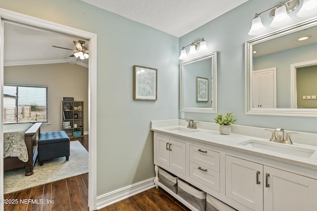 bathroom featuring lofted ceiling, hardwood / wood-style flooring, ceiling fan, vanity, and a textured ceiling