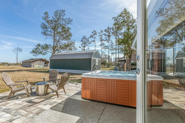 view of patio / terrace with a hot tub and a shed