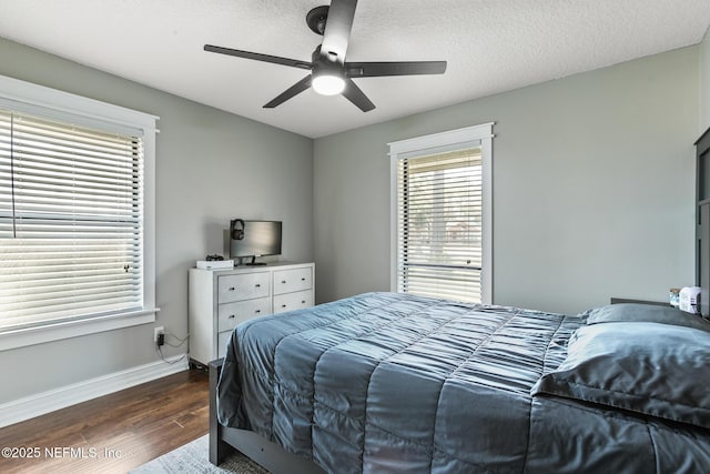 bedroom with ceiling fan, dark hardwood / wood-style floors, and a textured ceiling