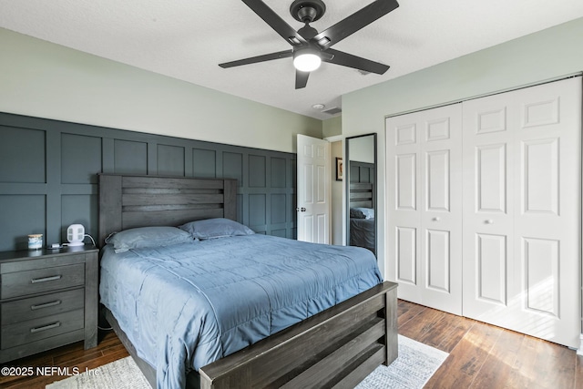 bedroom featuring ceiling fan, dark hardwood / wood-style flooring, and a closet