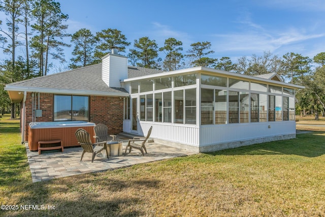 rear view of property with a patio area, a hot tub, a sunroom, and a lawn