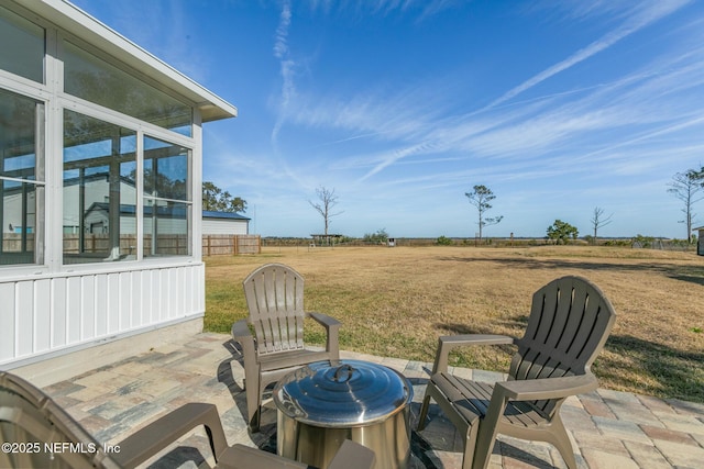 view of patio / terrace featuring a sunroom and a rural view