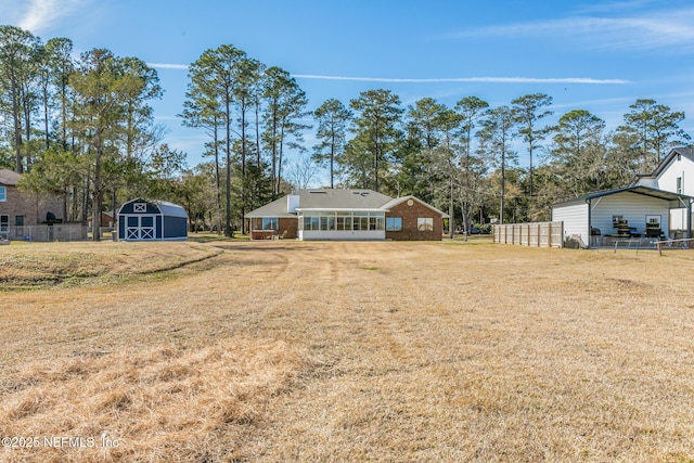 view of yard with a sunroom and a shed