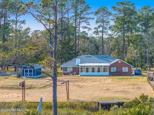 view of front of house featuring a storage shed and a front lawn