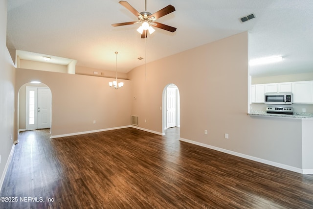 unfurnished living room with dark hardwood / wood-style flooring, ceiling fan with notable chandelier, and vaulted ceiling