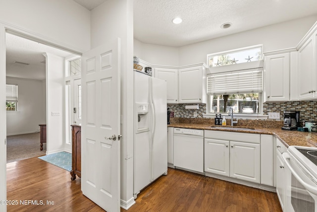 kitchen with tasteful backsplash, white cabinetry, sink, dark hardwood / wood-style flooring, and white appliances