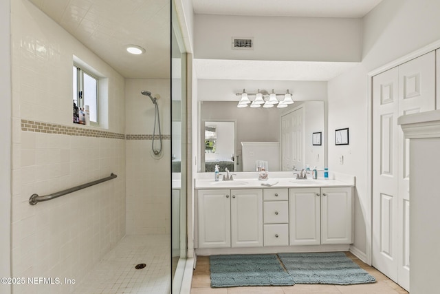 bathroom with vanity and a tile shower