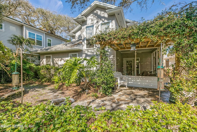 rear view of house featuring ceiling fan and a patio