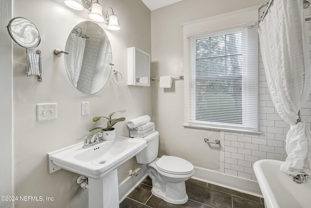 bathroom with toilet and tile patterned flooring