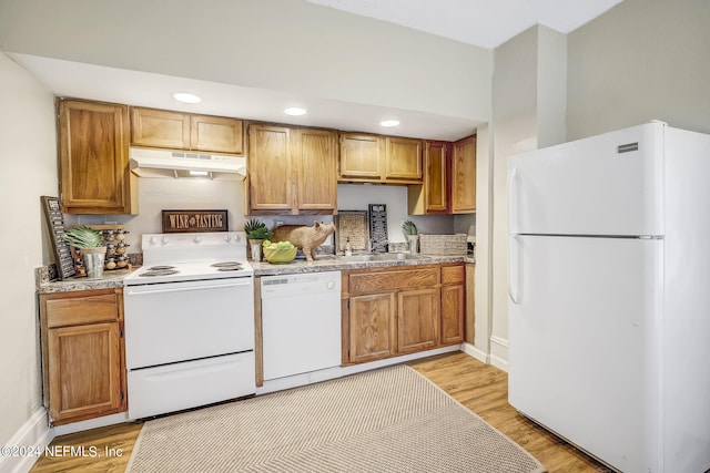 kitchen featuring white appliances, sink, and light hardwood / wood-style flooring