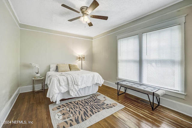 bedroom featuring crown molding, ceiling fan, dark hardwood / wood-style flooring, and a textured ceiling