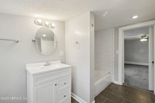 bathroom with vanity, tiled shower / bath, a textured ceiling, and ceiling fan