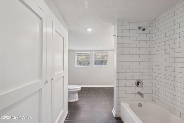 bathroom with tile patterned floors, toilet, tiled shower / bath combo, and a textured ceiling