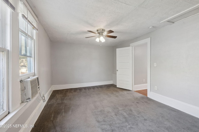 unfurnished room featuring cooling unit, ceiling fan, dark carpet, and a textured ceiling