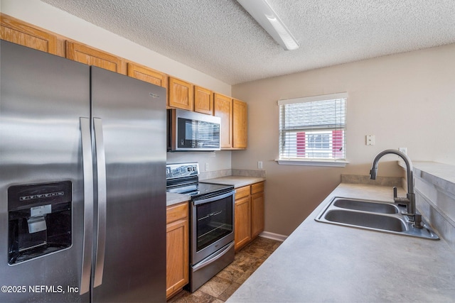 kitchen featuring stainless steel appliances, sink, and a textured ceiling