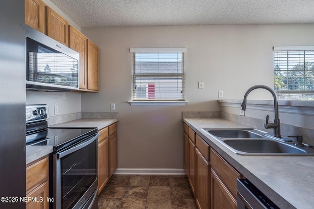 kitchen featuring sink, stainless steel appliances, and a textured ceiling