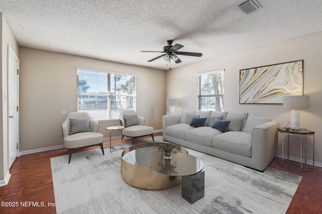 living room featuring hardwood / wood-style flooring, ceiling fan, and a textured ceiling