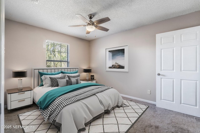 bedroom with ceiling fan, light colored carpet, and a textured ceiling