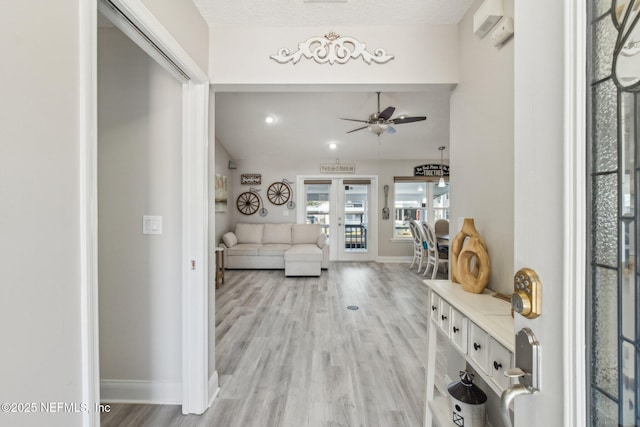 living room featuring ceiling fan, vaulted ceiling, and light hardwood / wood-style flooring