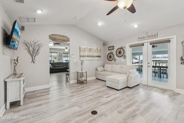 living room featuring vaulted ceiling, ceiling fan, light wood-type flooring, and french doors