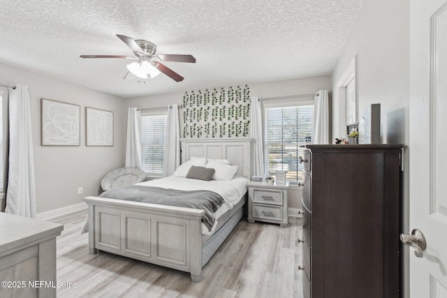 bedroom featuring ceiling fan, a textured ceiling, and light wood-type flooring