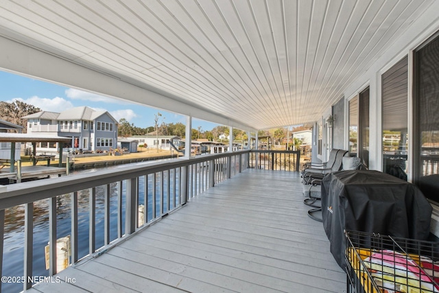 wooden terrace with a water view and grilling area