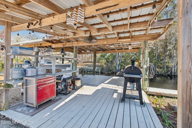 wooden deck with a boat dock and a water view