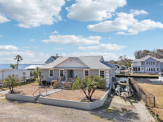 view of front of home with a water view and central AC unit