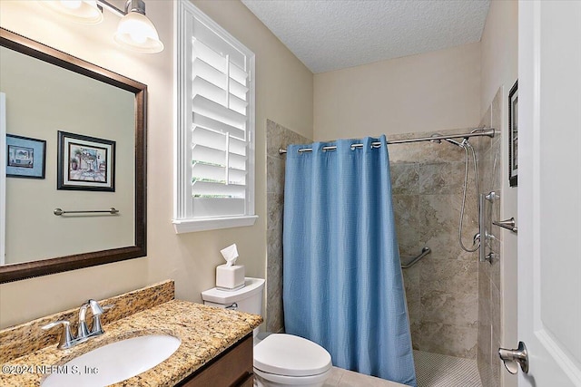 bathroom featuring vanity, toilet, a textured ceiling, and walk in shower