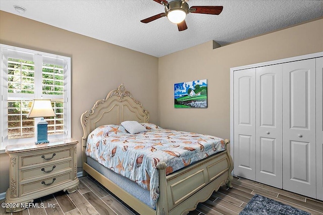 bedroom with ceiling fan, a closet, and a textured ceiling