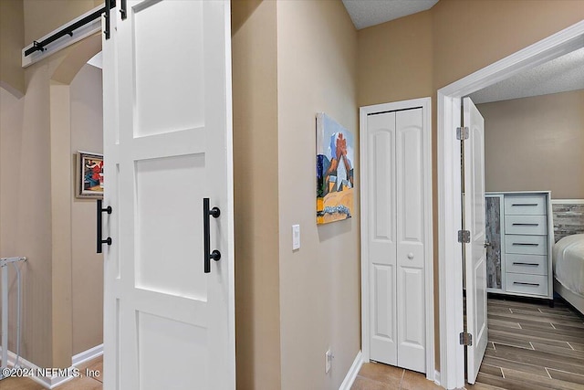 hall featuring wood-type flooring and a barn door