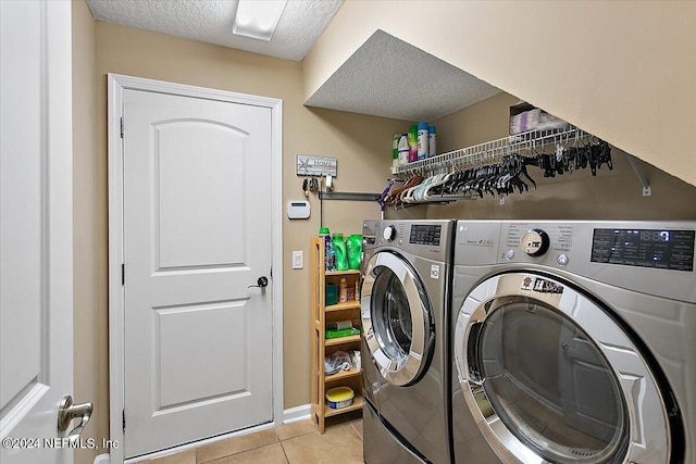 washroom with separate washer and dryer, a textured ceiling, and light tile patterned floors