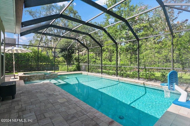 view of swimming pool with an in ground hot tub, glass enclosure, and a patio area