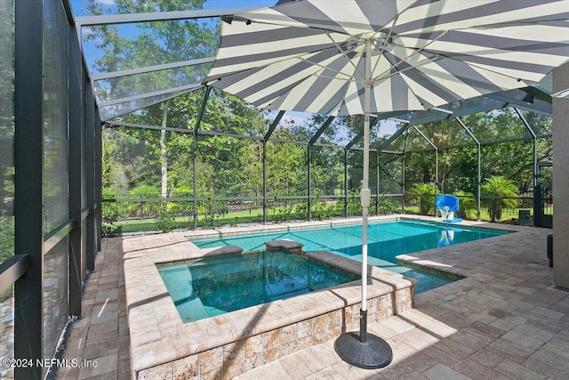 view of swimming pool with a patio, glass enclosure, and an in ground hot tub