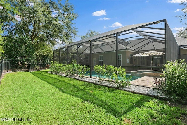 view of yard with glass enclosure and a pool with hot tub