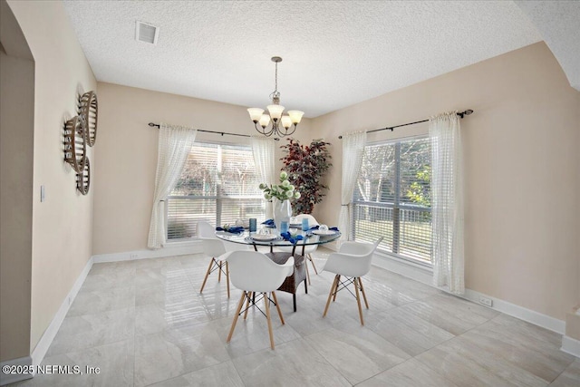 dining room with a textured ceiling and a chandelier