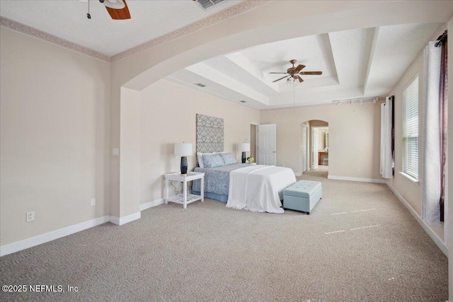 carpeted bedroom with ceiling fan, ornamental molding, and a tray ceiling