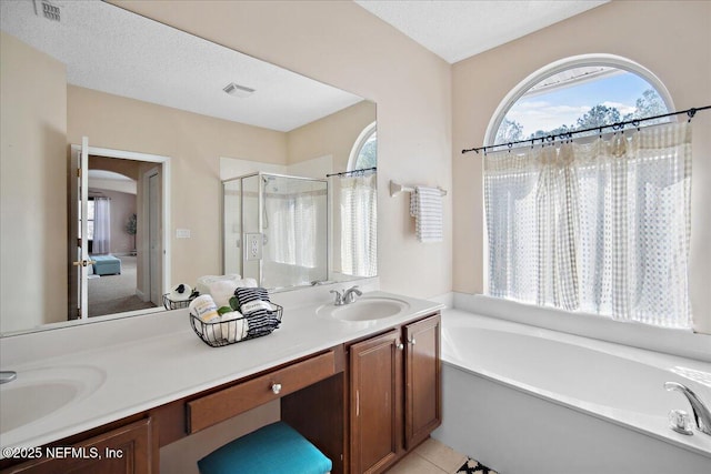 bathroom with vanity, tile patterned flooring, independent shower and bath, and a textured ceiling